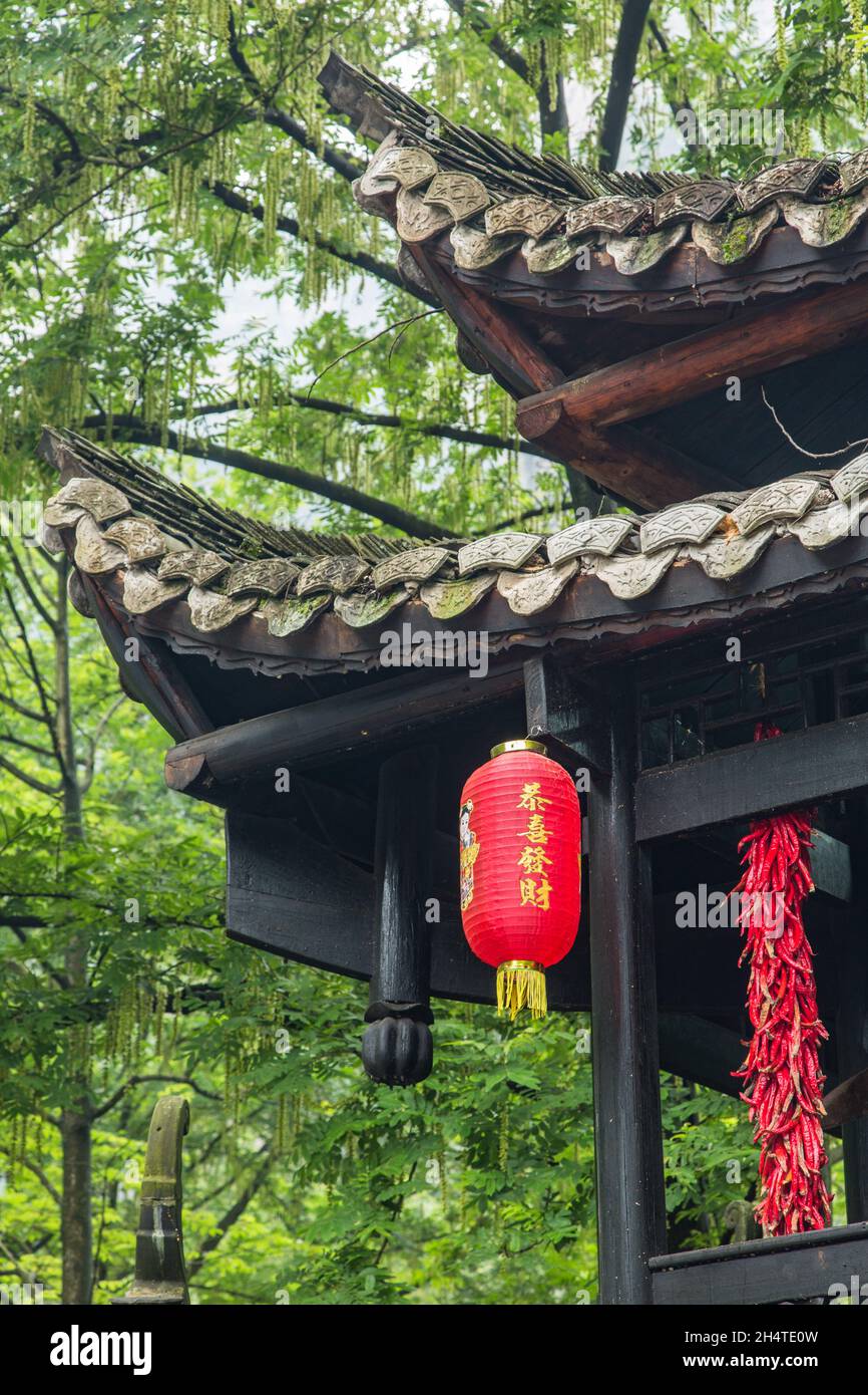 Strands of red chili peppers and Chinese lanterns on a traditional wooden building in Zhangjiajie National Forest Park, Hunan, China. Stock Photo