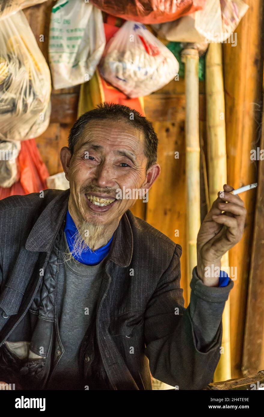 An older Chinese man selling traditional herbal medicines by a trail in Zhangjiajie National Forest Park, China. Stock Photo