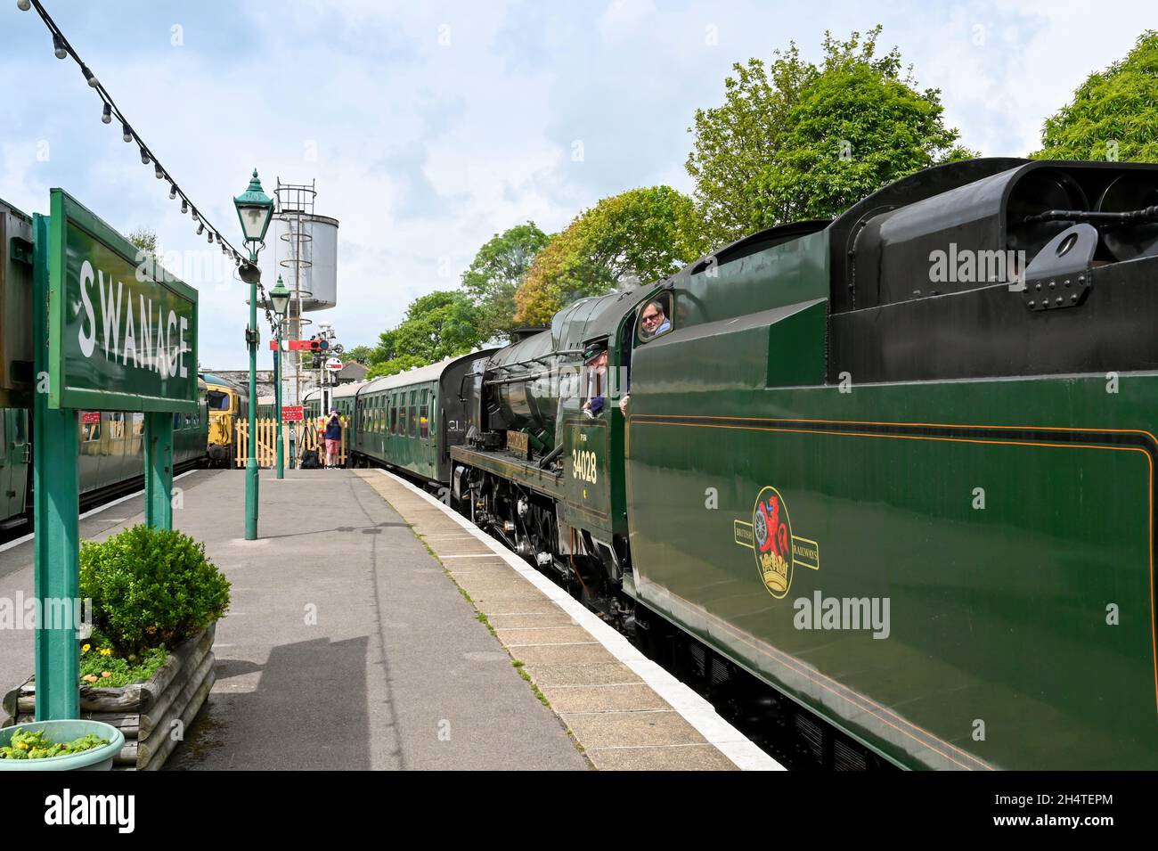 Swanage, England - June 2021: Vintage steam locomotive arriving at Swanage railway station with a train of old carriages Stock Photo