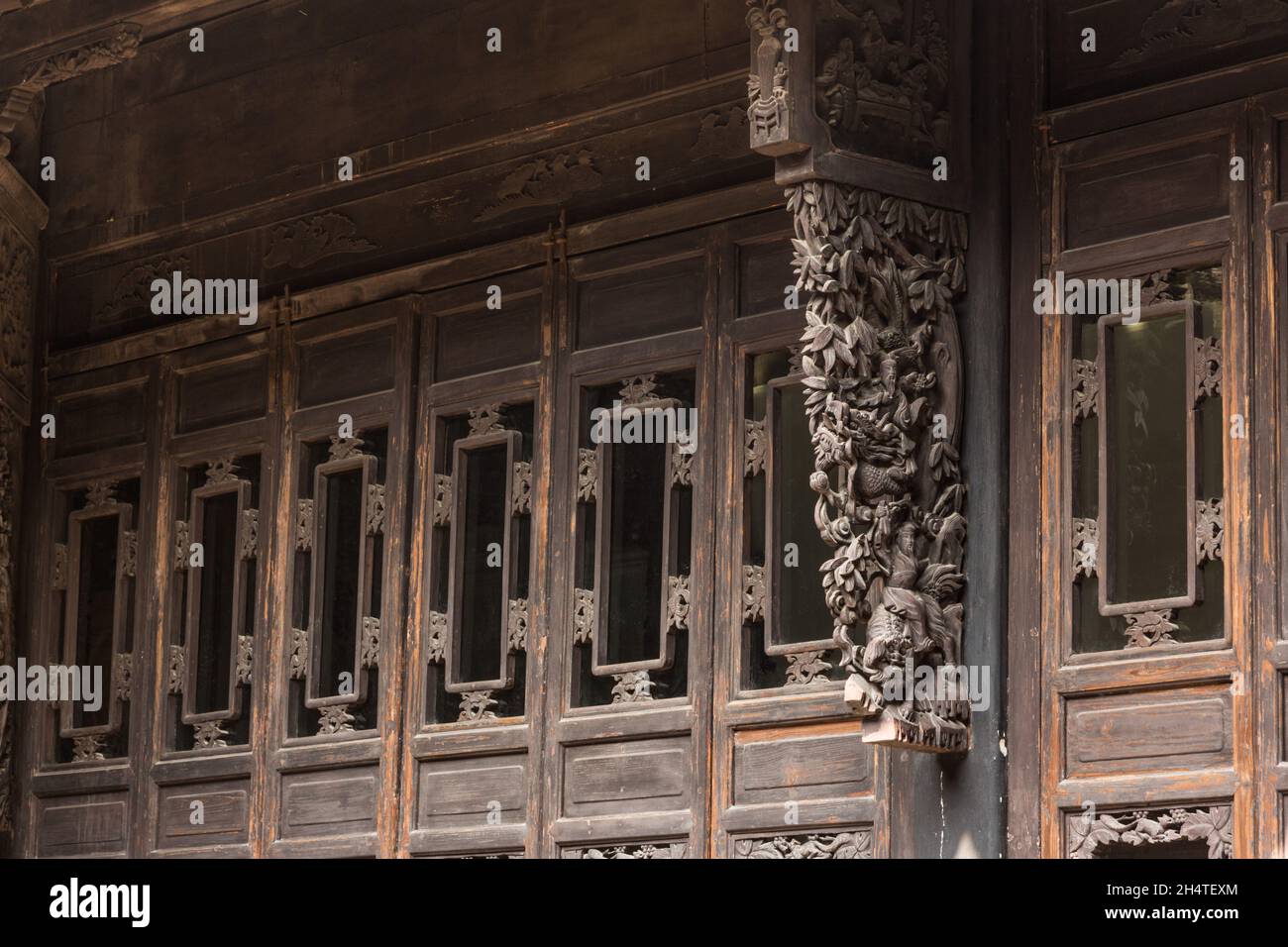 Elaborate wood carving of a peacock & people in tradtional dress on an old building in Wuzhen, China. Stock Photo