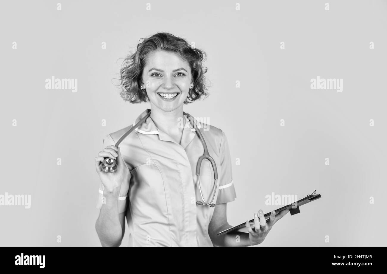 Portrait of lovely nurse with a folder. She is wearing a stethoscope. nurse holding binder and wearing stethoscope. Smiling female doctor with a Stock Photo