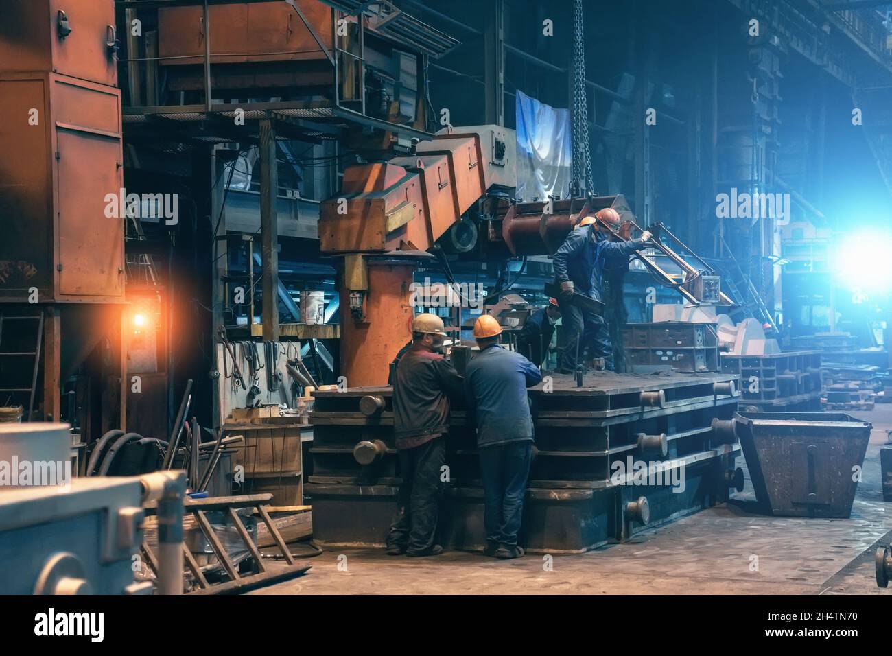 Steel mill interior inside. Workers in workshop of metallurgical plant. Foundry and heavy industry building inside background. Stock Photo