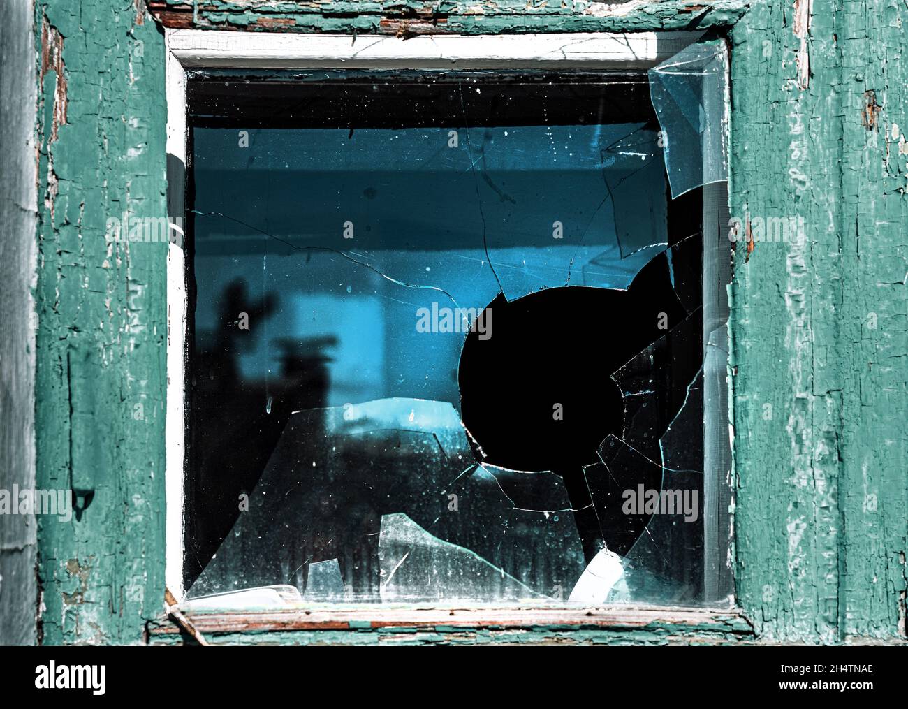 Broken window. Cracked glass with hole. Vandalism, destruction and accident concept. Stock Photo