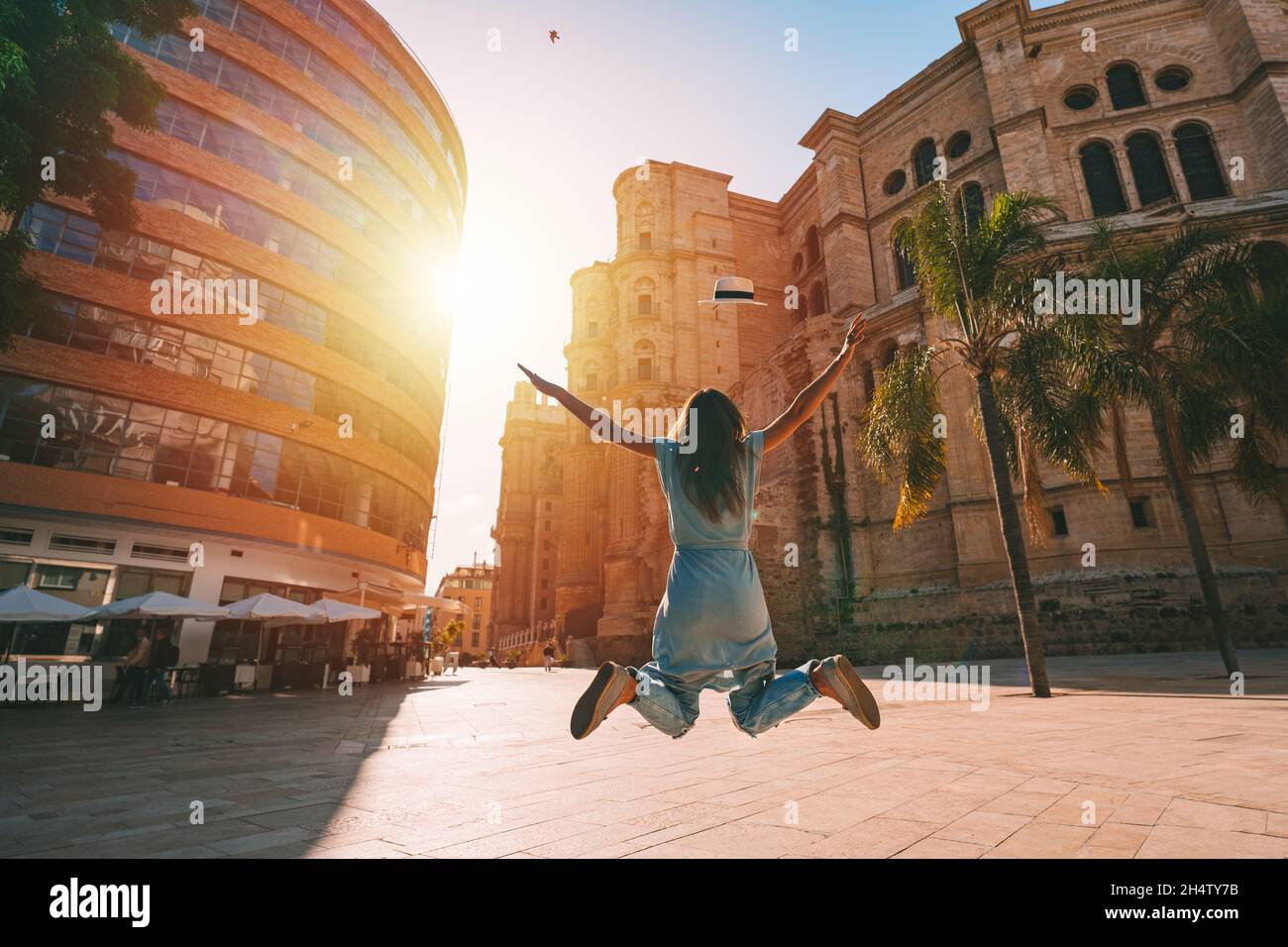Happy carefree woman jumping and enjoying life on summer vacation in Spain Stock Photo
