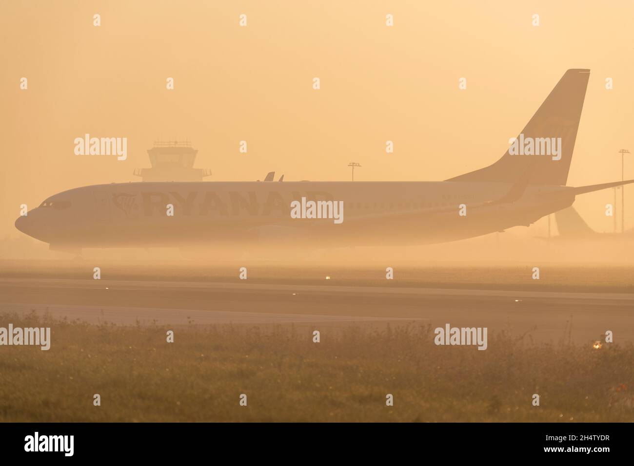 Ryanair Boeing 737 airliner jet plane taxiing out for an early morning flight at London Southend Airport, Essex, UK, in fog and mist at sunrise Stock Photo