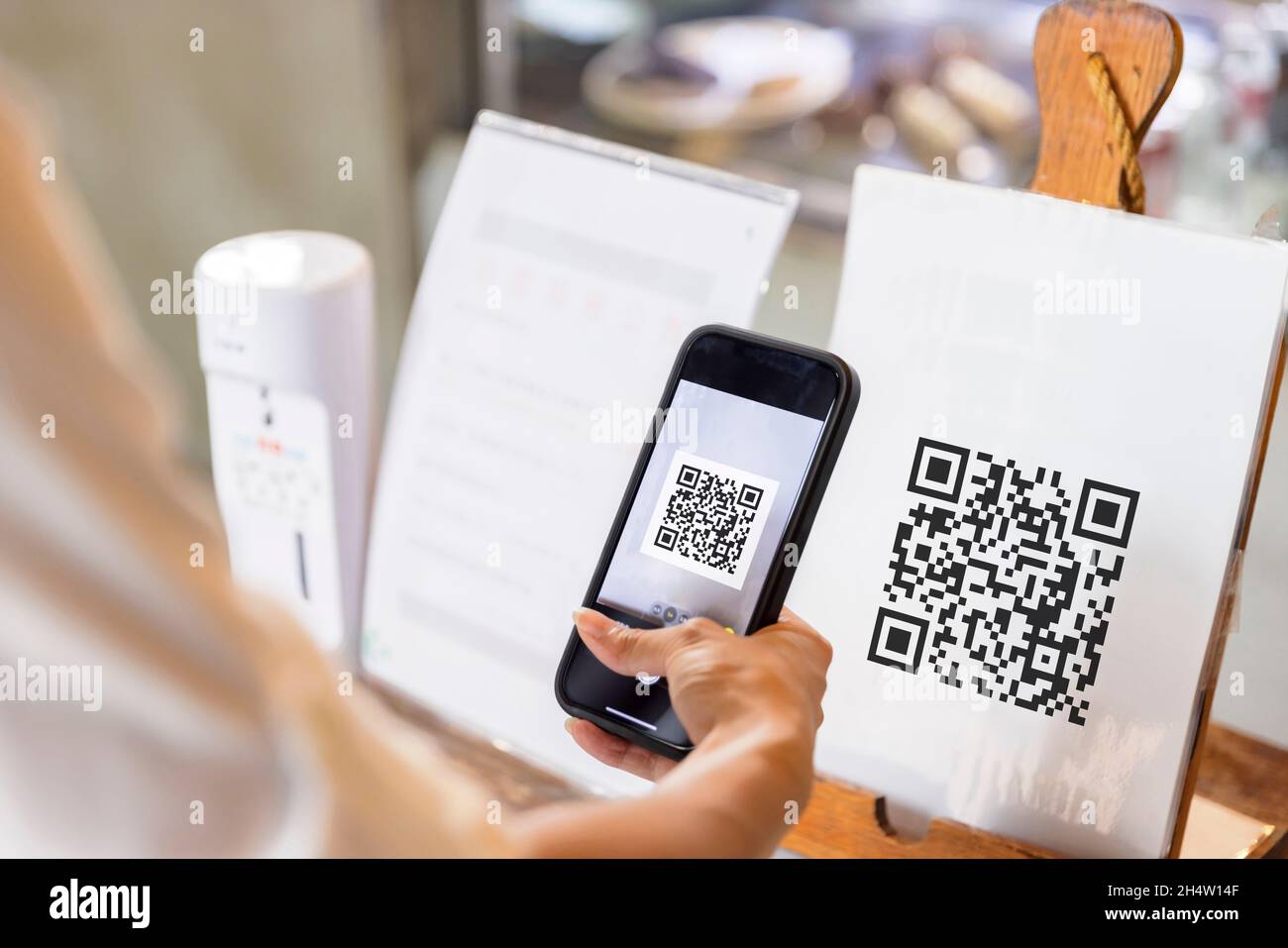 Hand of woman using the smartphone to scan QR code. Stock Photo