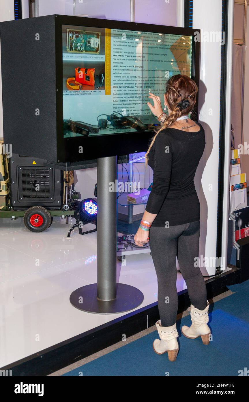 ASRA MURNI, Gemelli Trade stand at the Farnborough International Airshow 2014, trade show. Female using touch screen advertising display Stock Photo