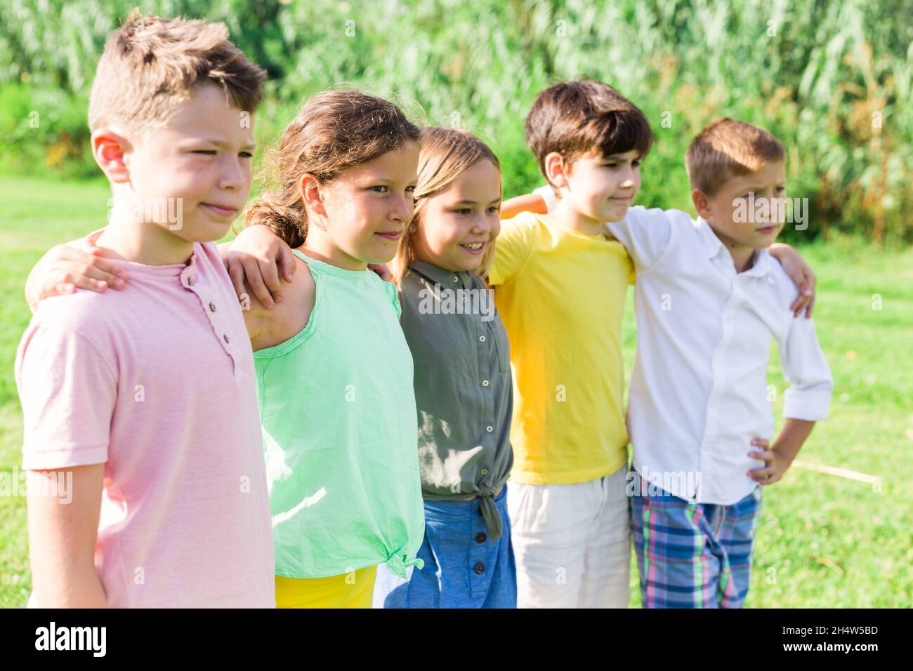 Portrait of five glad children who are walking and posing in park Stock ...