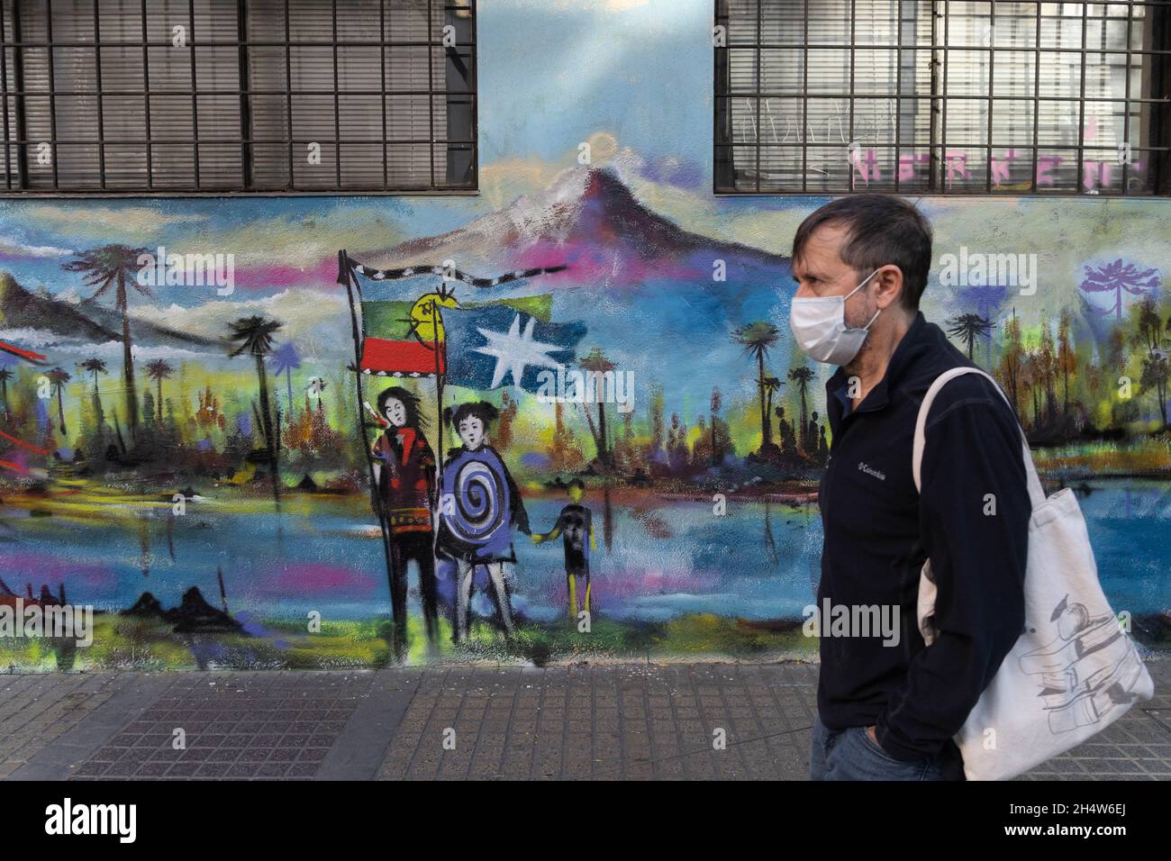 Santiago, Metropolitana, Chile. 4th Nov, 2021. A man with a face mask walks in front of a mural painted in support of the Mapuches. (Credit Image: © Matias Basualdo/ZUMA Press Wire) Stock Photo
