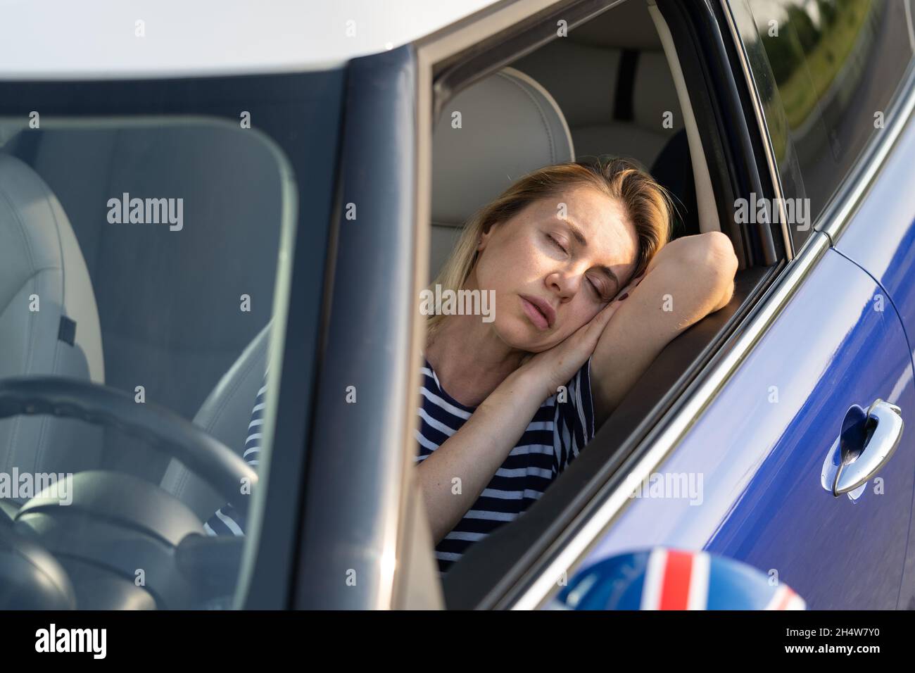 Woman tired of driving sleep on front seat. Female travel by car on ...