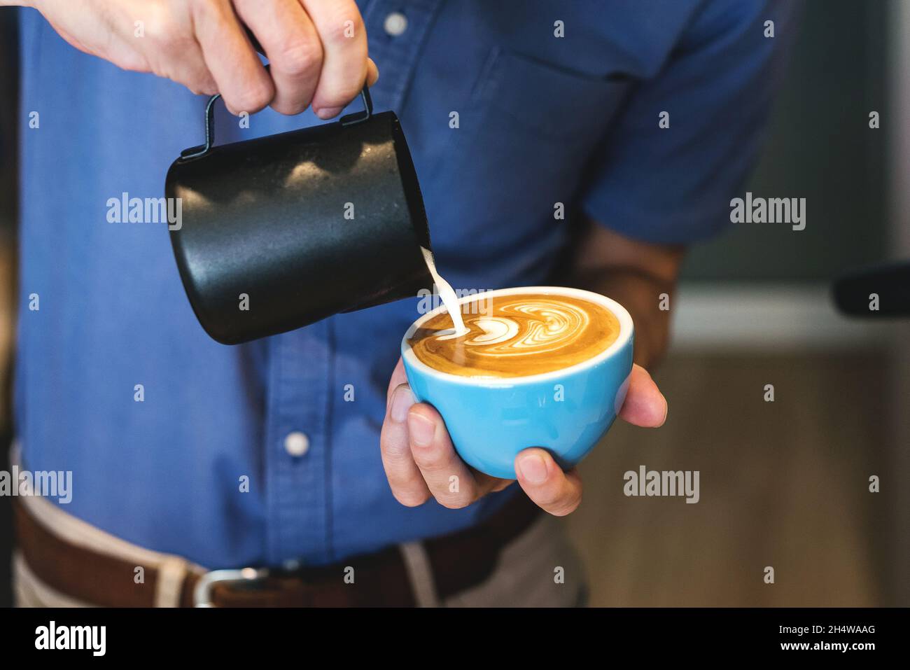 Barista making coffee latte art in a coffee shop Stock Photo Alamy