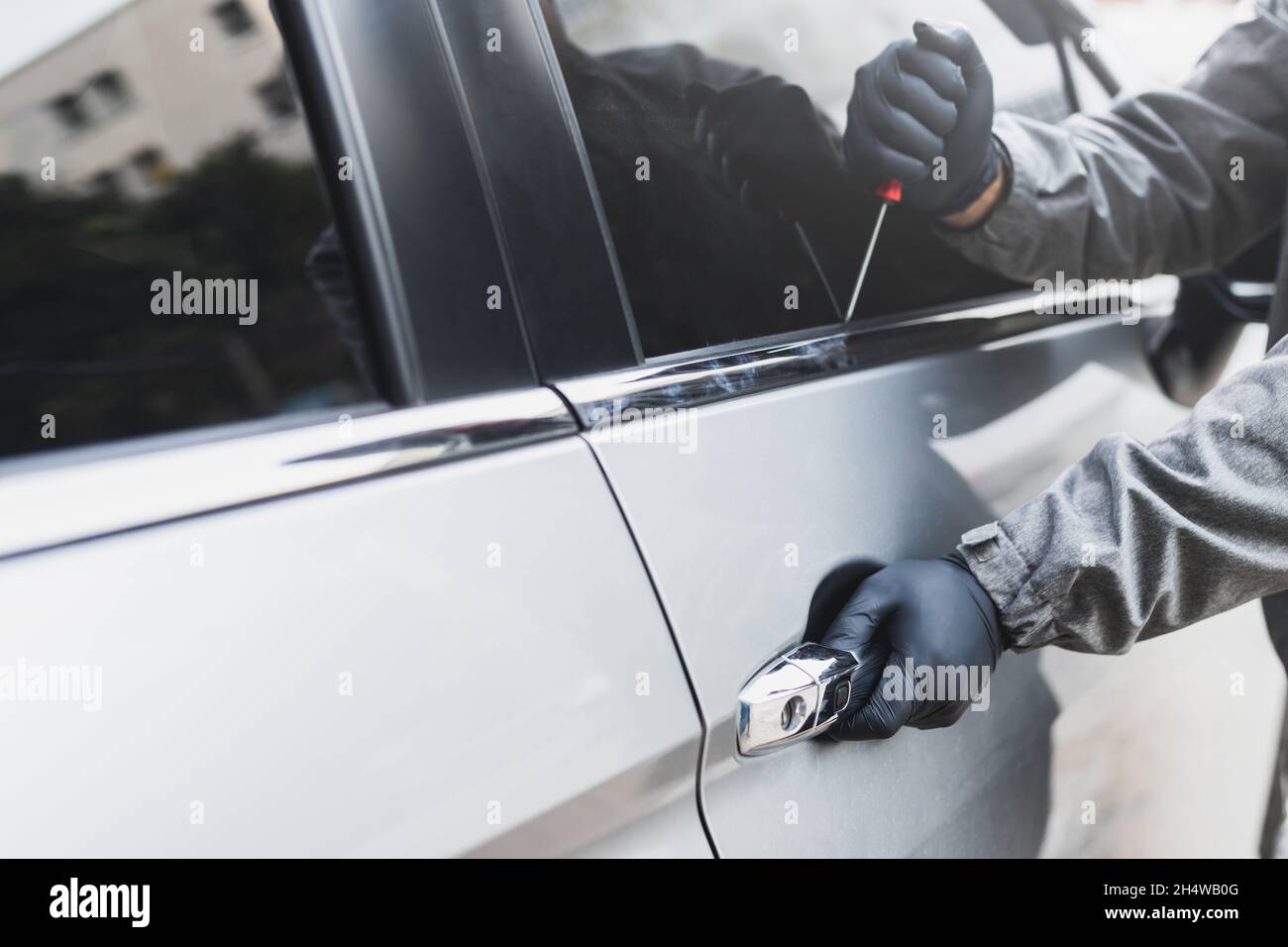 The thief uses a screwdriver Stealing a car at car windows. The vehicle