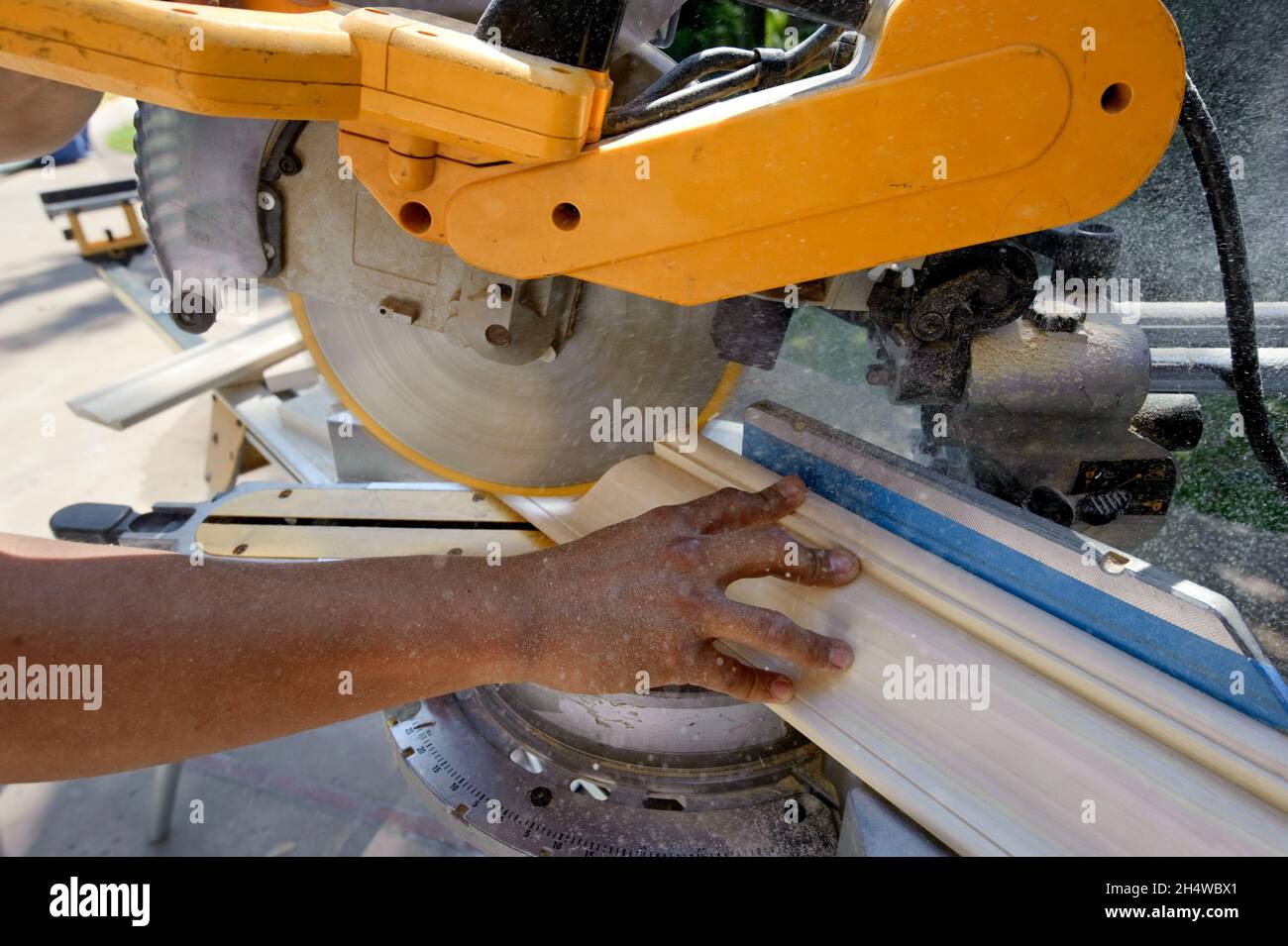 Finish carpenter using a compound slide miter saw to bevel crown