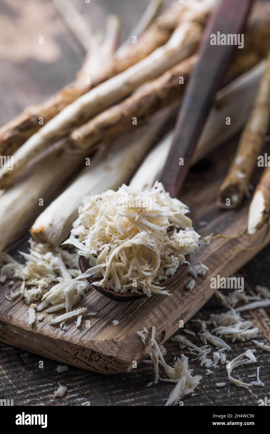 Fresh organic horseradish or Horse-radish root on wooden cutting board. Stock Photo