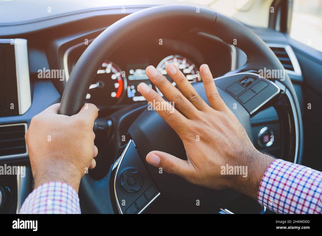 Hand man pushing car horn while driving car. Stock Photo