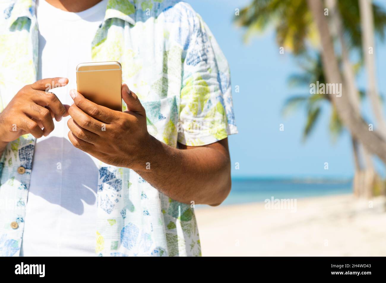 Man on the beach using smartphone. Stock Photo