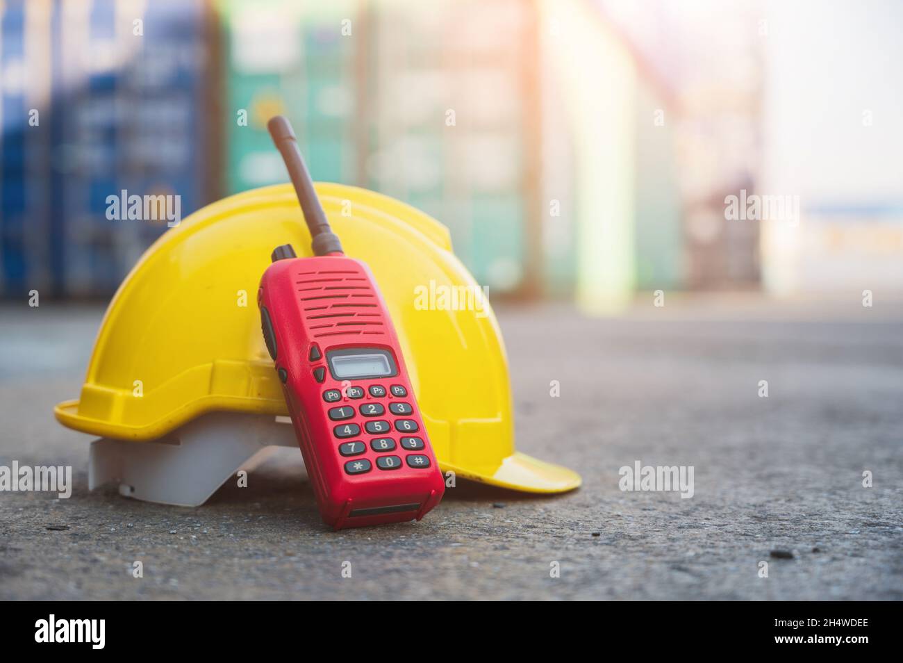 Radio walkie talkie and helmet hard hat on the floor at Container cargo