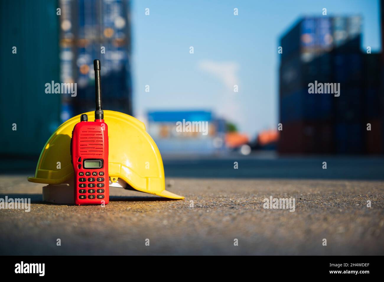 Radio walkie talkie and helmet hard hat on the floor at Container cargo