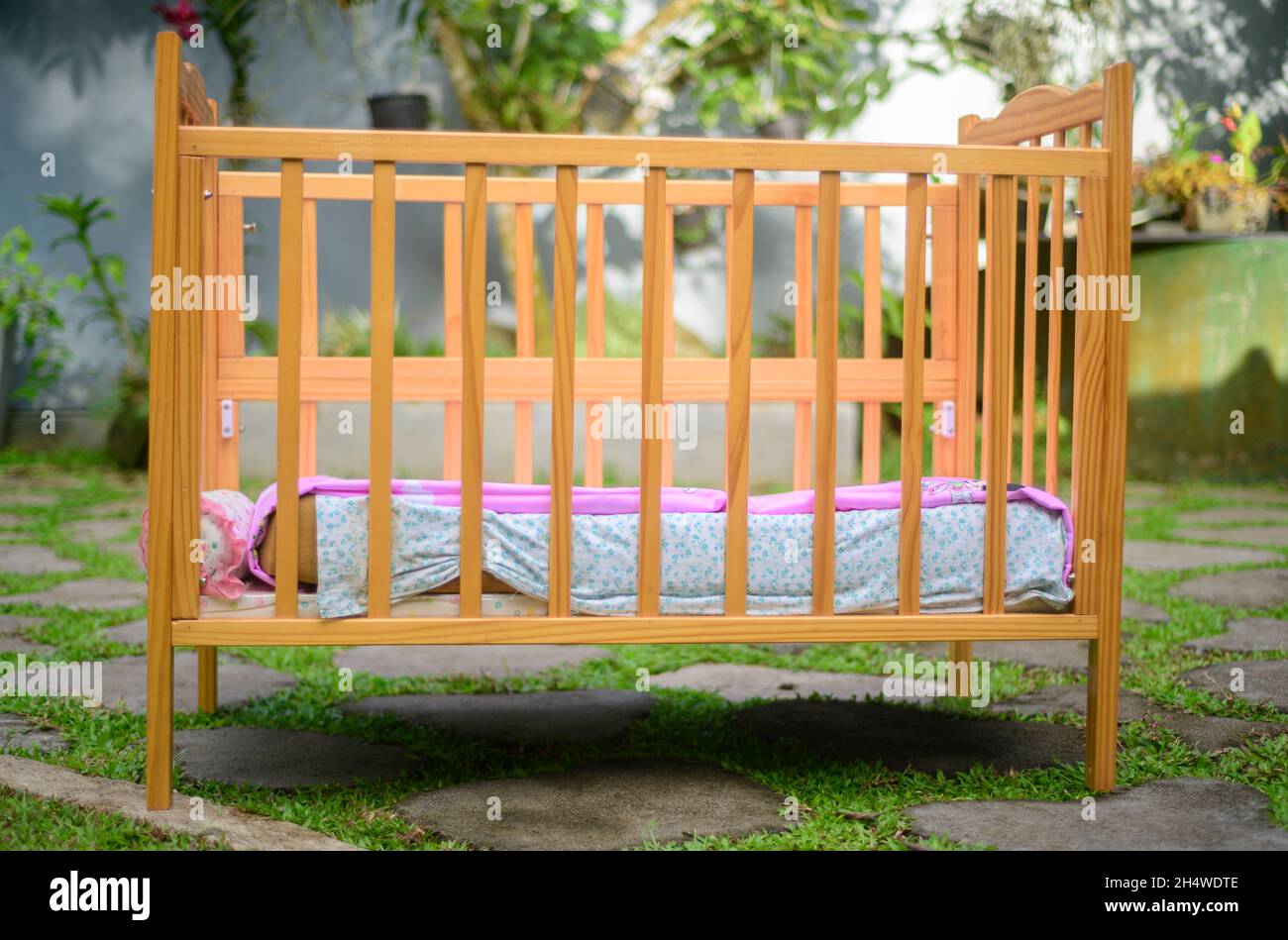 Baby crib with soft mattress and a cozy sheets, stylish wooden finish