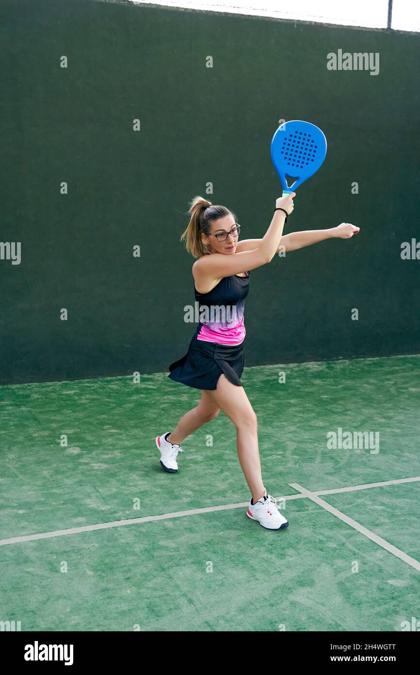 Mujer en pantalones cortos jugando tenis de pádel en la cancha Fotografía  de stock - Alamy