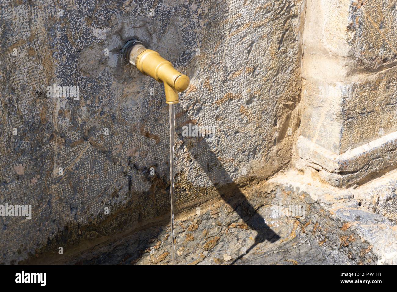 Faucet of an ancient stone fountain Stock Photo