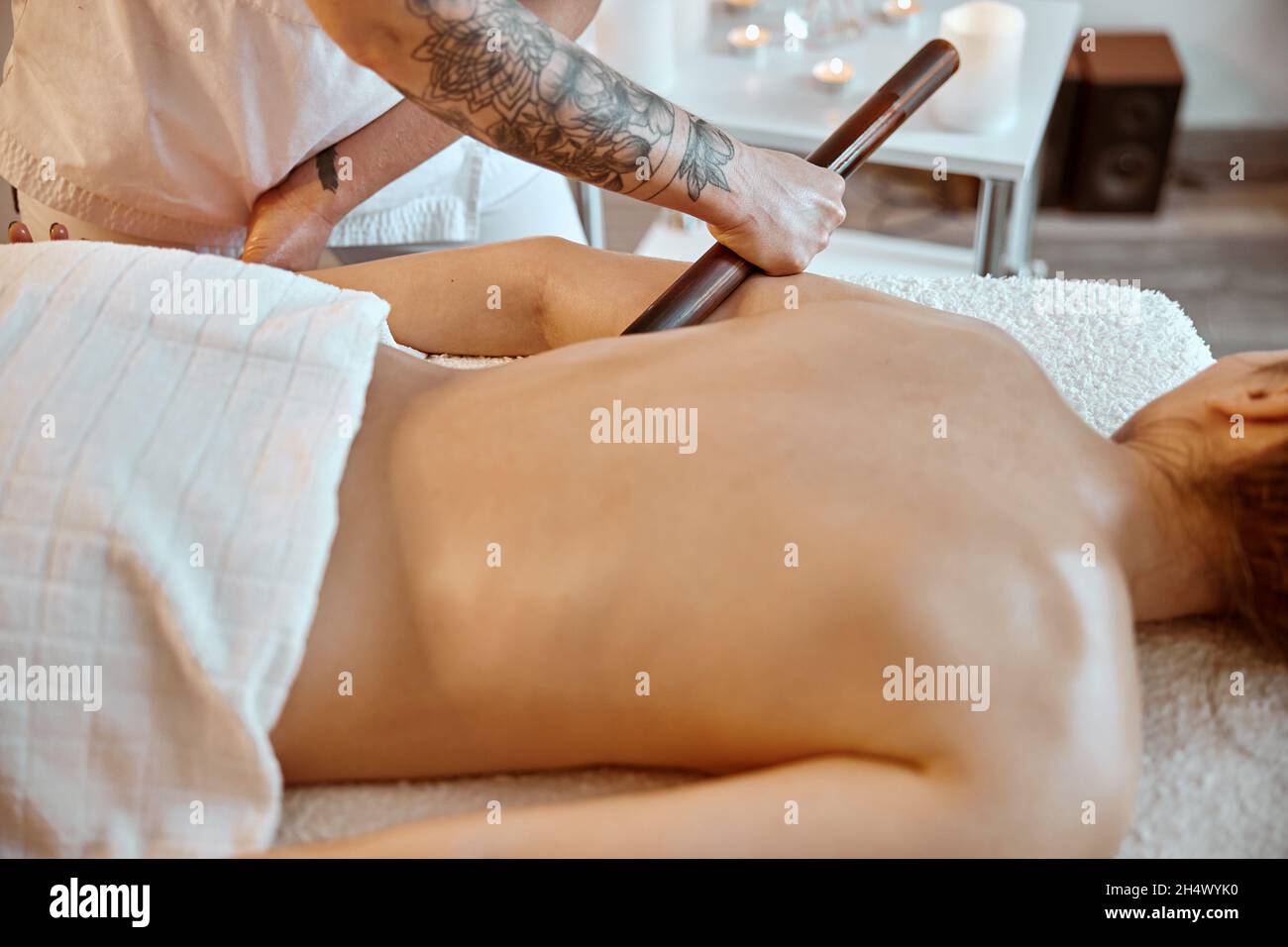 Professional confident massage master is doing procedures to caucasian woman in minimalistic modern cabinet Stock Photo