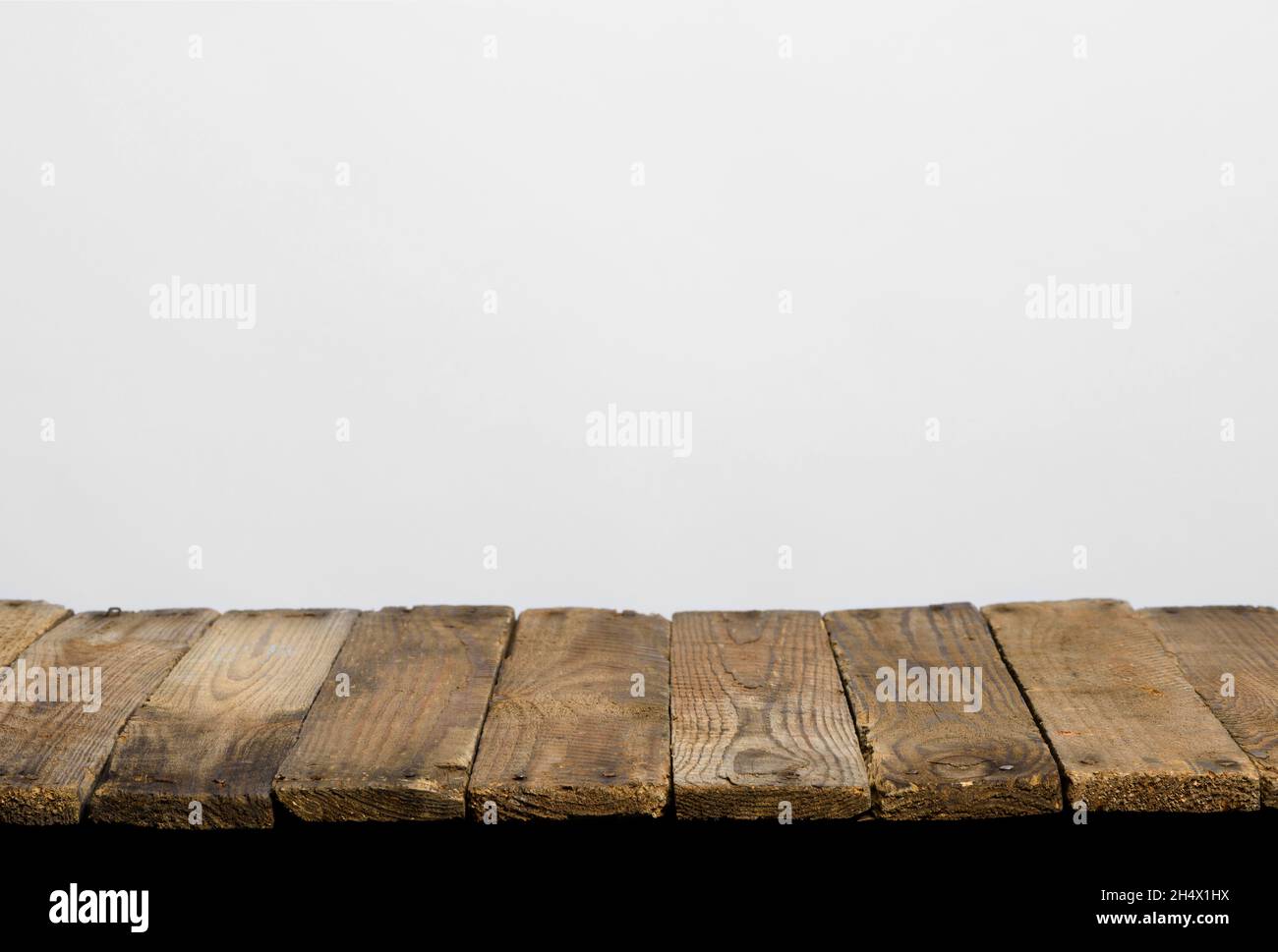 Empty wooden table top from rustic old wood planks, neutral gray background. Stock Photo