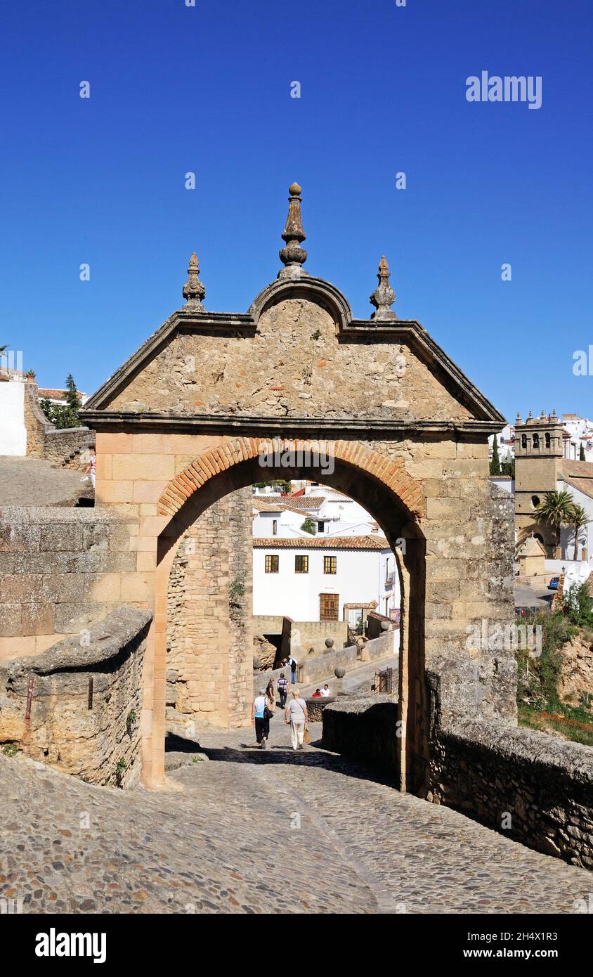 View through the Philip V arch towards the old town and the Nuestro Padre Jesus church, Ronda, Malaga Province, Spain. Stock Photo