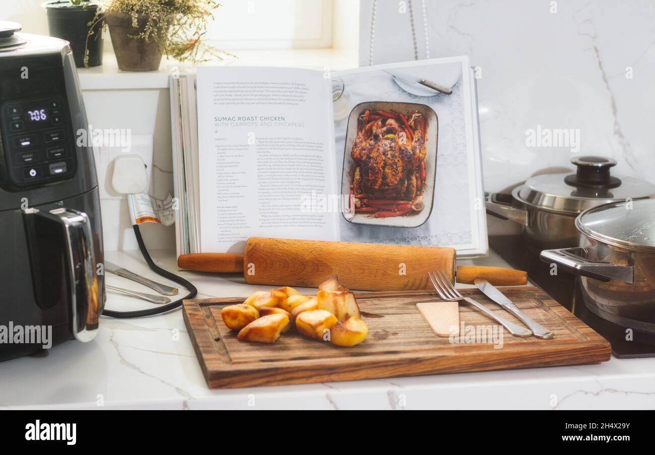 Recipe book open showing instructions to make roast chicken on a kitchen worktop Stock Photo
