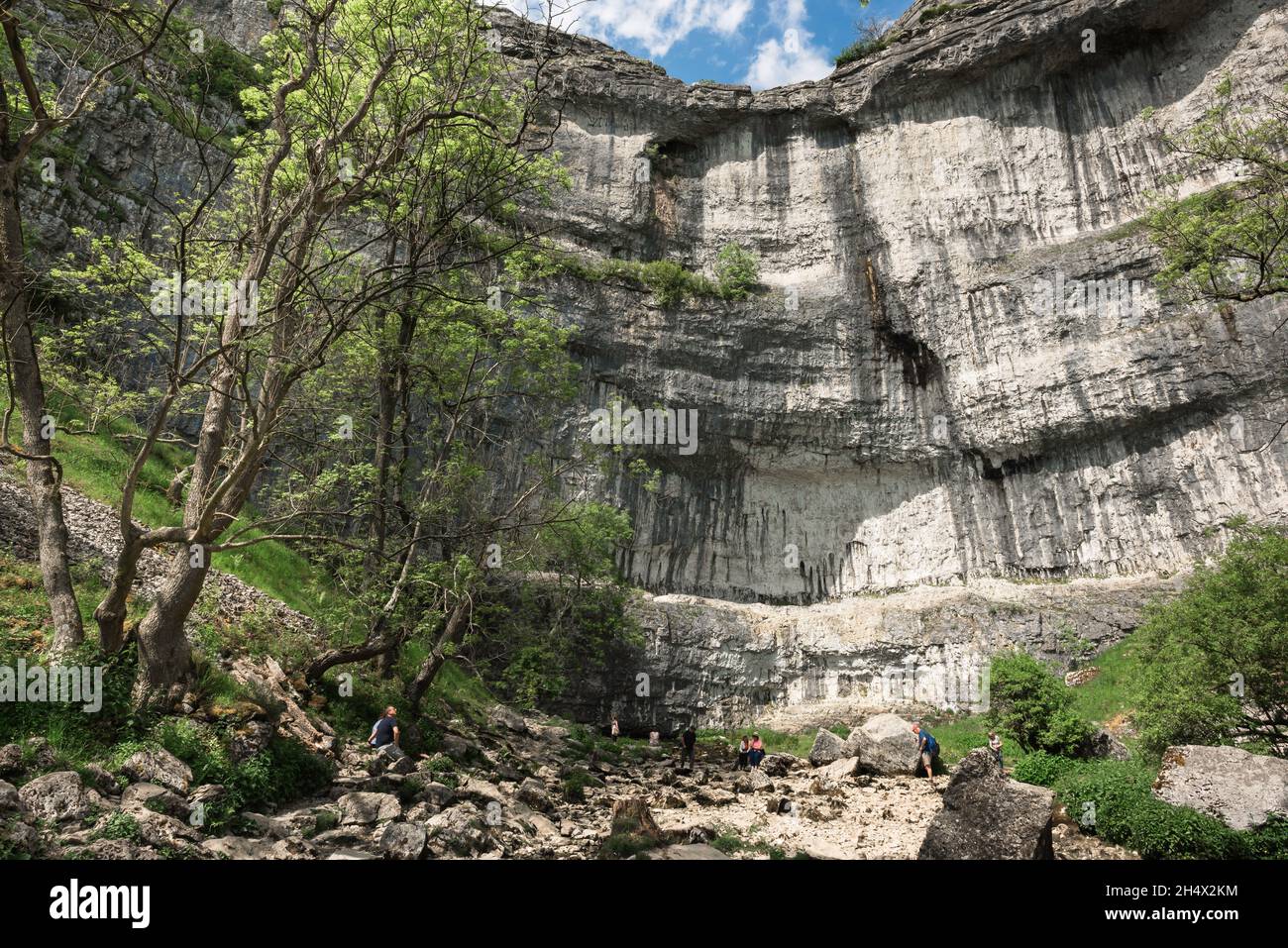 Yorkshire, view in summer of people visiting Malham Cove, a 260ft cliff sited in Malhamdale, an area of outstanding natural beauty in North Yorks, UK Stock Photo