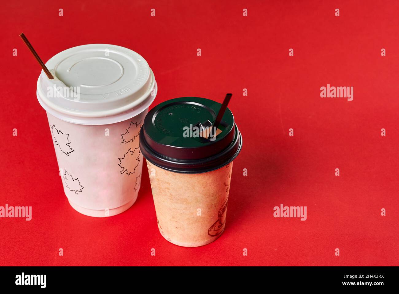 Two single-use plastic coffee cups on red background with copy space Stock Photo