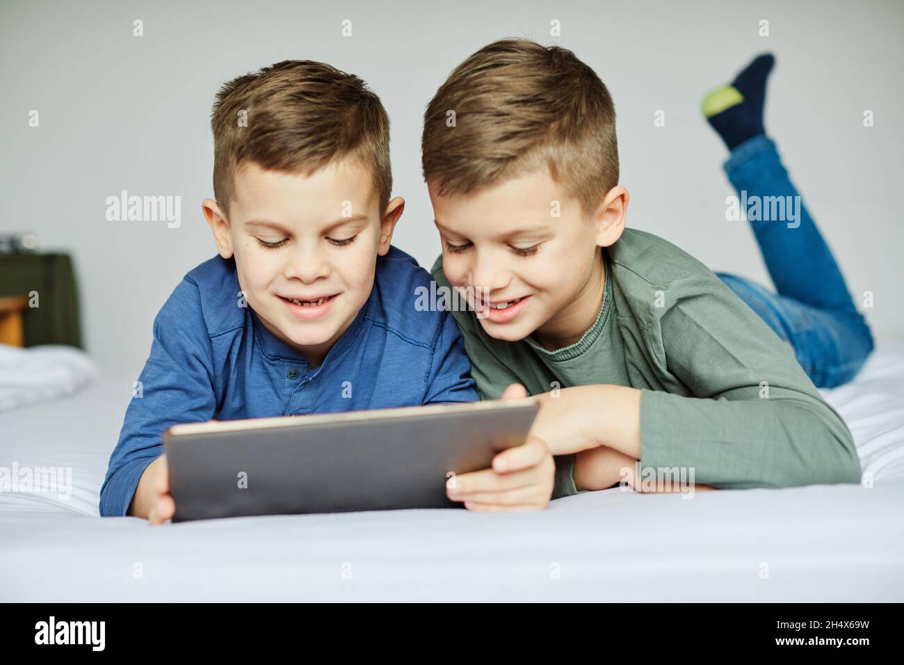 child brother friend having fun tablet laptop happy kid Stock Photo