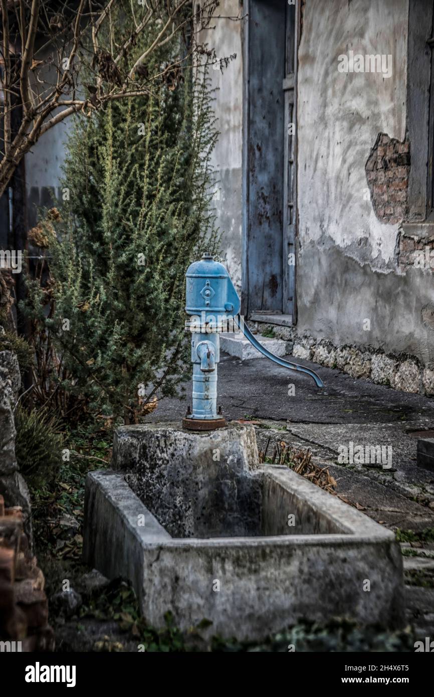 Blue vintage faucet in a countryside yard Stock Photo