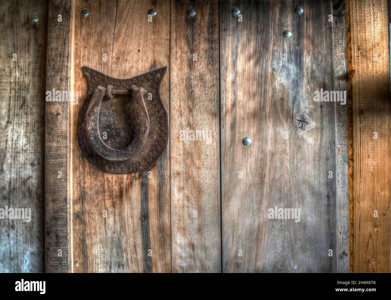 Horseshoe and two horseshoe nails on wooden plank Stock Photo - Alamy