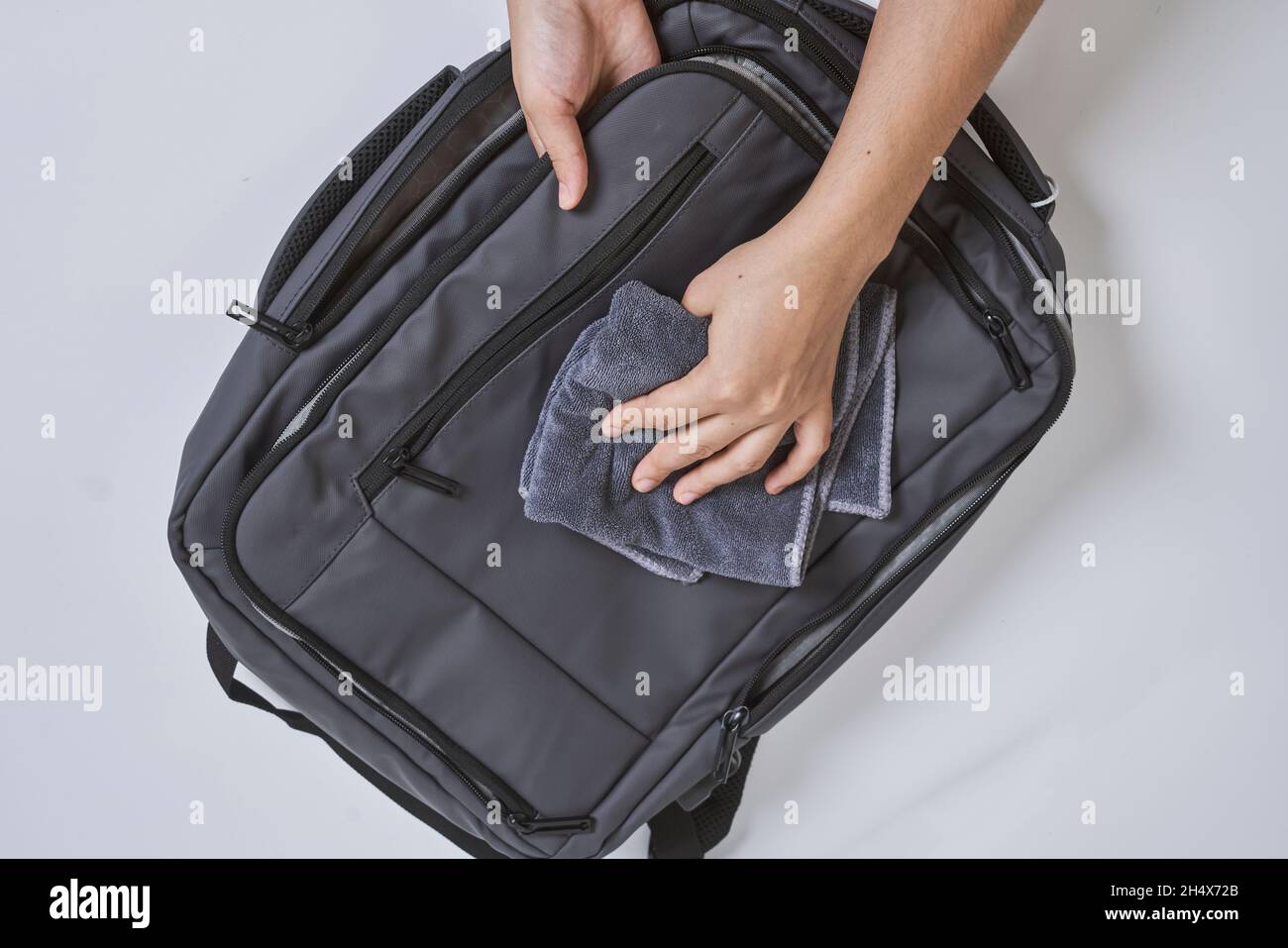 Cleaning backpack with washcloth. A person wipes off dirt or dust from