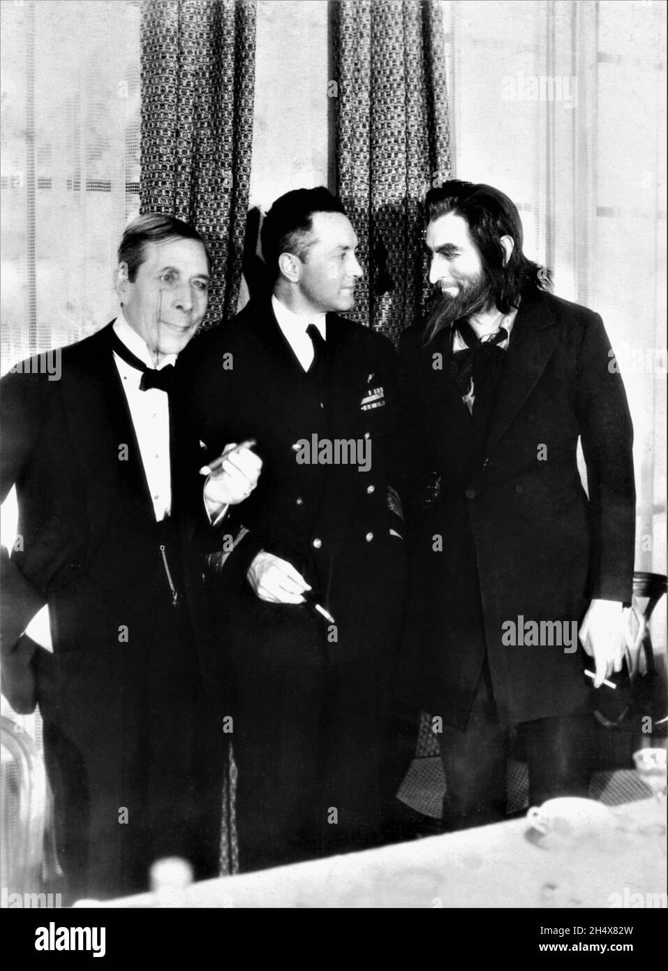 Antarctic Explorer Commander RICHARD E. BYRD stands between GEORGE ARLISS and JOHN BARRYMORE (in costume as SVENGALI) during a visit to Warner Bros. Studio in Hollywood in early February 1931 Stock Photo