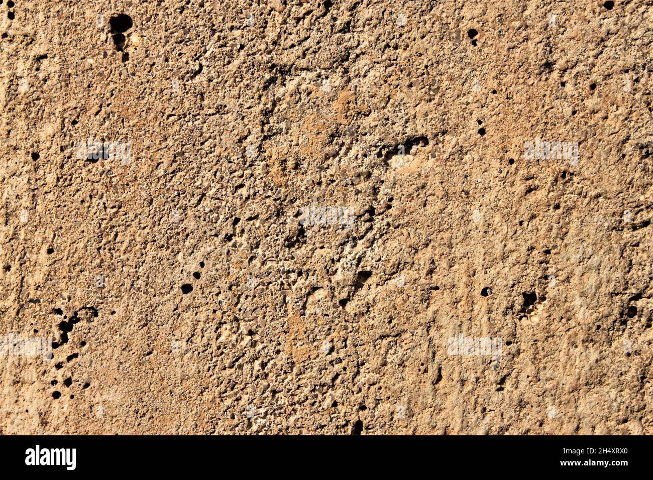 Old gray brown irregular concrete wall as background Stock Photo