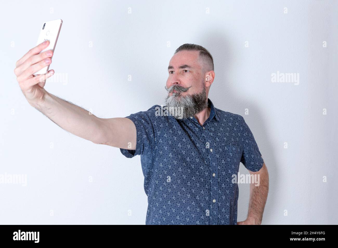 bearded hipster style in his 40s taking a selfie Stock Photo