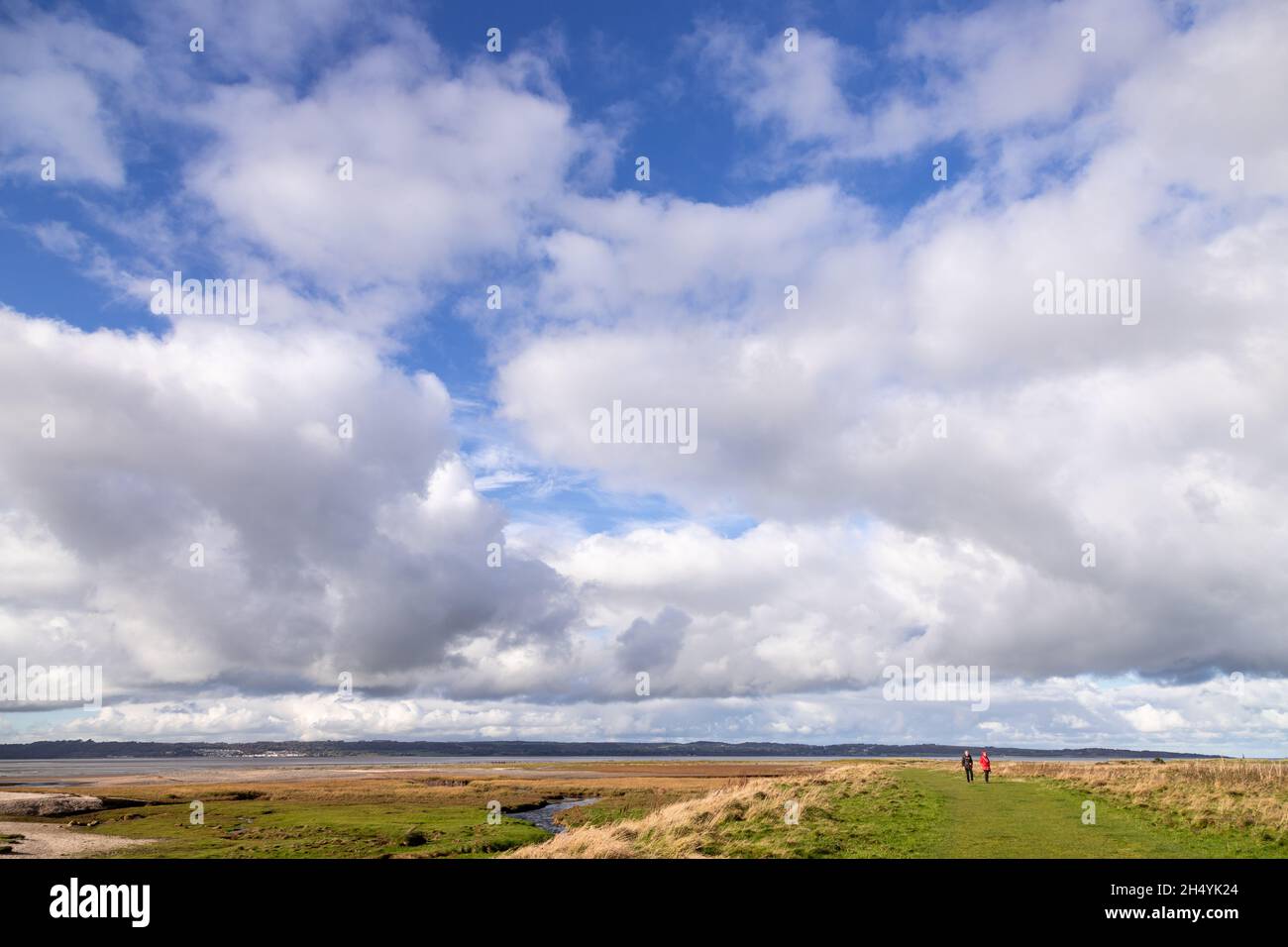 Walkers at Llanfairfechan salt marsh, North Wales coast Stock Photo