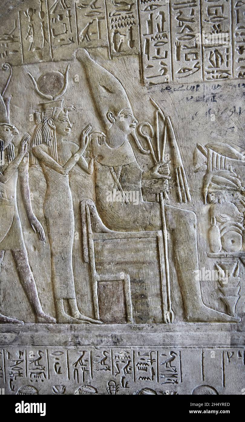 Detail of Ancient Egyptian stele of Rourou, 1294-1279, reign Seti I. Louvre Museum C92 or N243. Osiris seated, white crown; Isis standing, horns dislo Stock Photo
