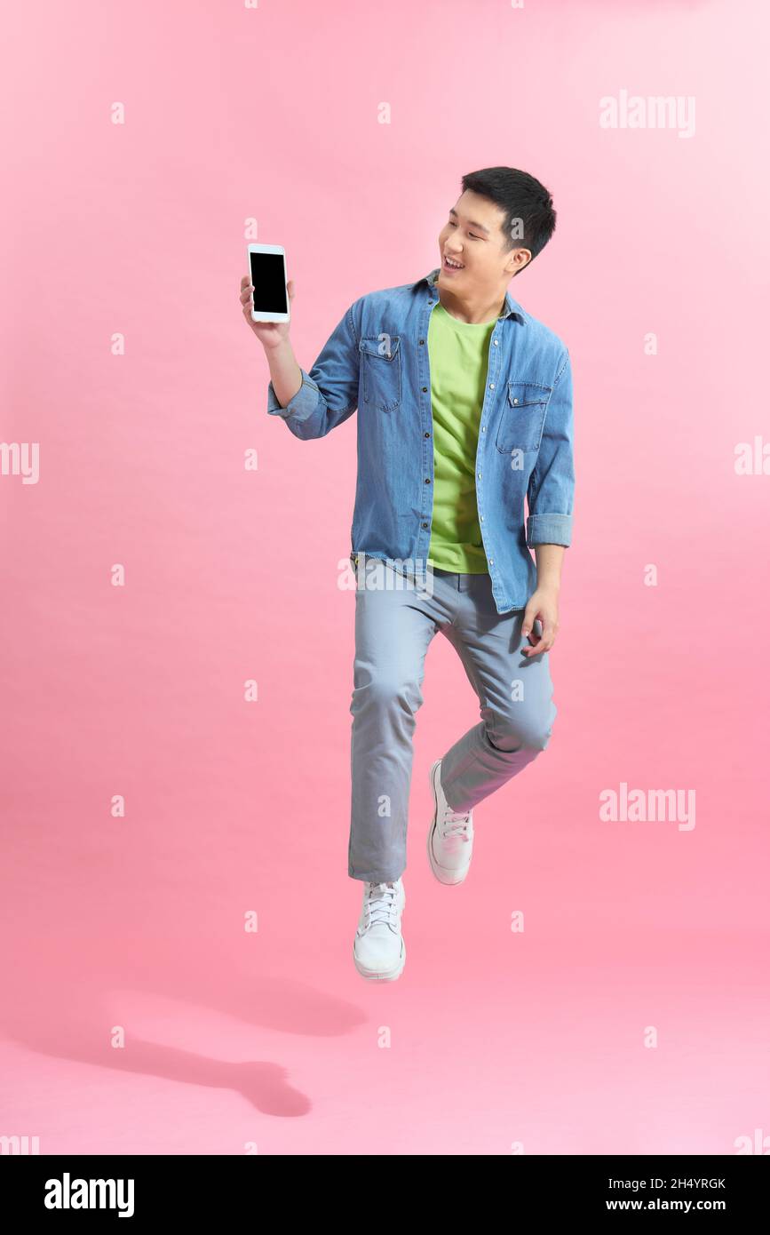 Happy handsome young man showing the smart phone and jumping Stock ...