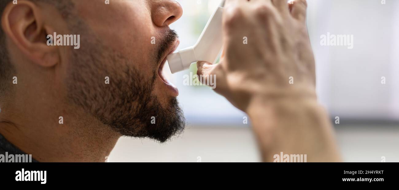 Man With Asthma Using An Asthma Inhaler For Preventing Attacks Stock Photo