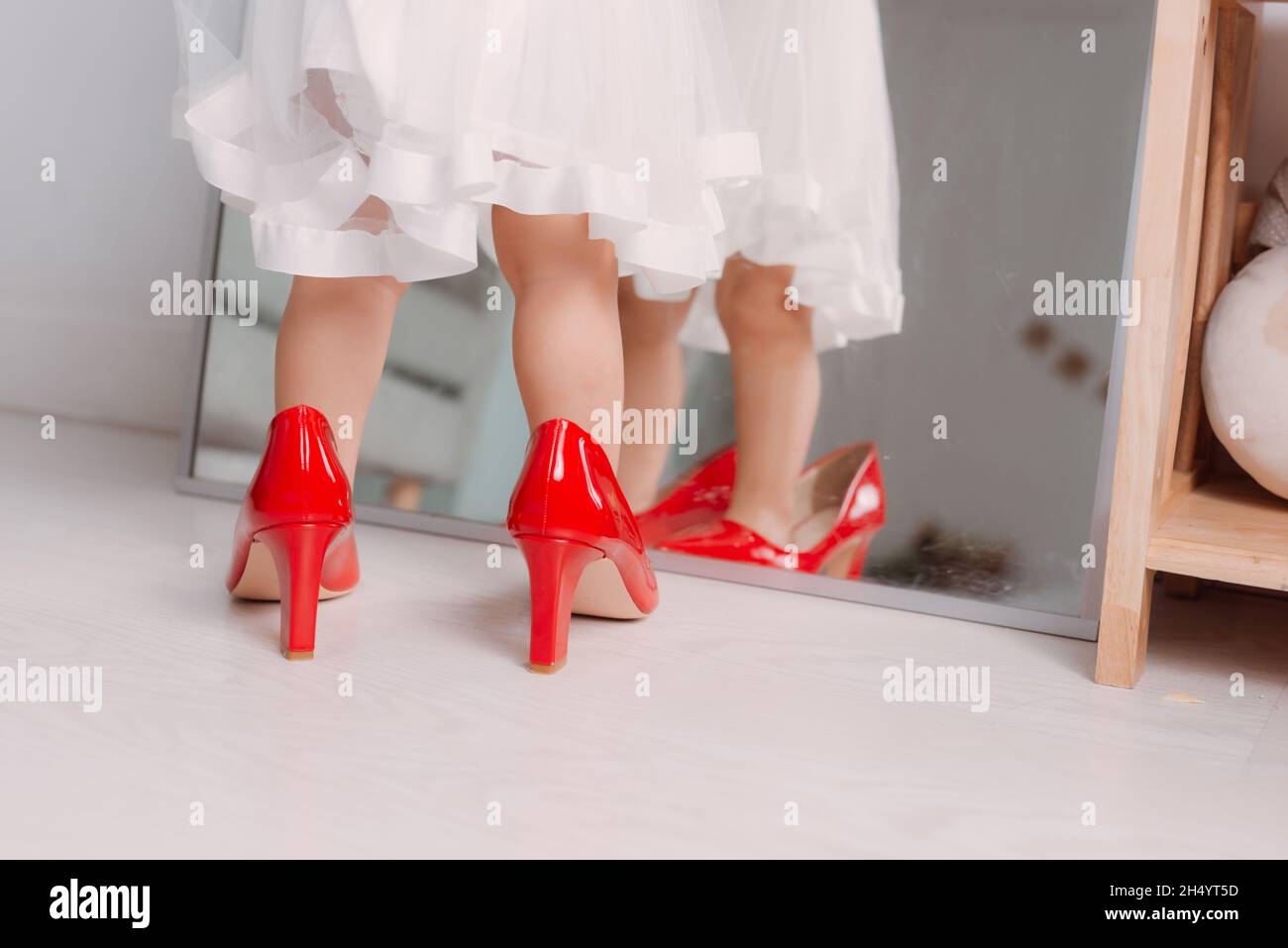 Cute little girl wearing high heeled shoes at home, closeup Stock Photo -  Alamy