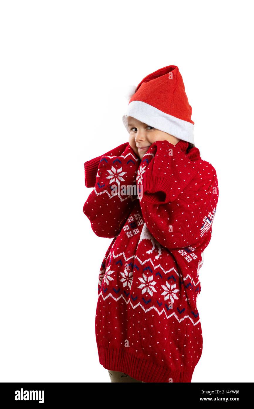 portrait of funny girl in red Santa Claus hat and red knitted oversized Christmas sweater with reindeer with long sleeves, isolated on white Stock Photo