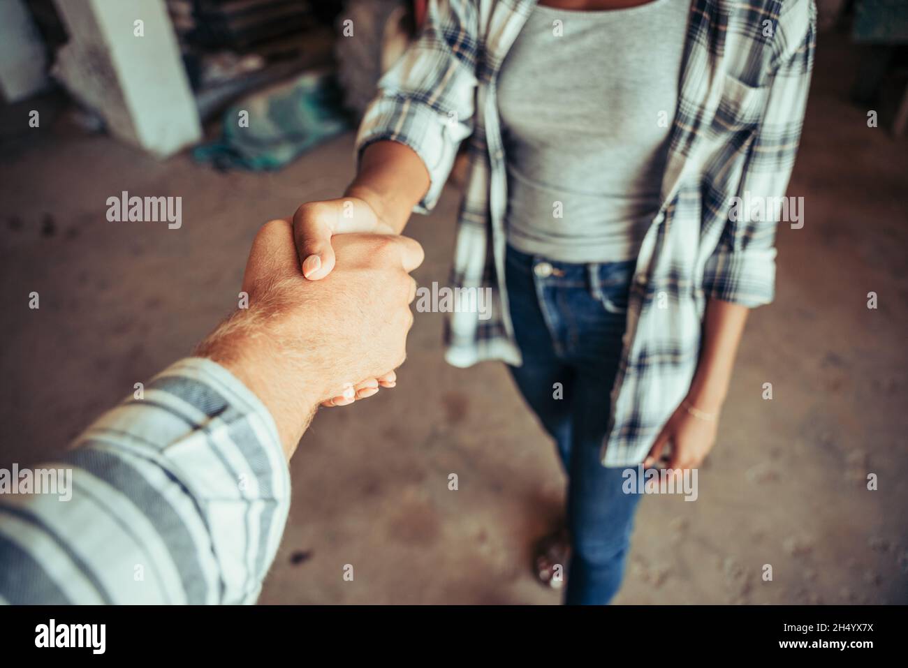 Close up mixed race couple hand shaking after long day of work Stock Photo