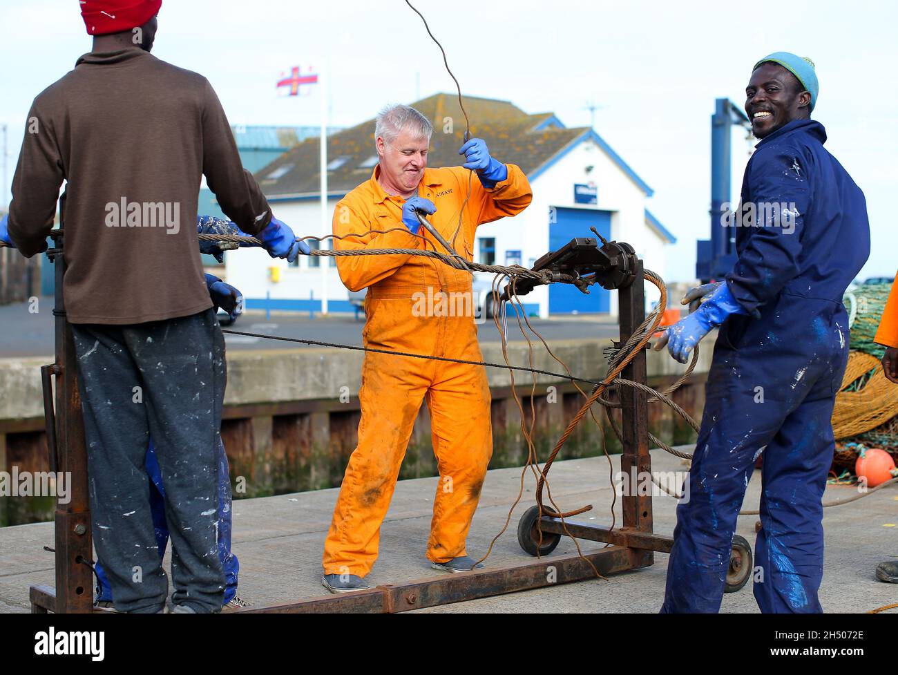Fishing men prepare their nets and boats before heading out to sea from Kilkeel Harbour in Co. Down, Northern Ireland Stock Photo