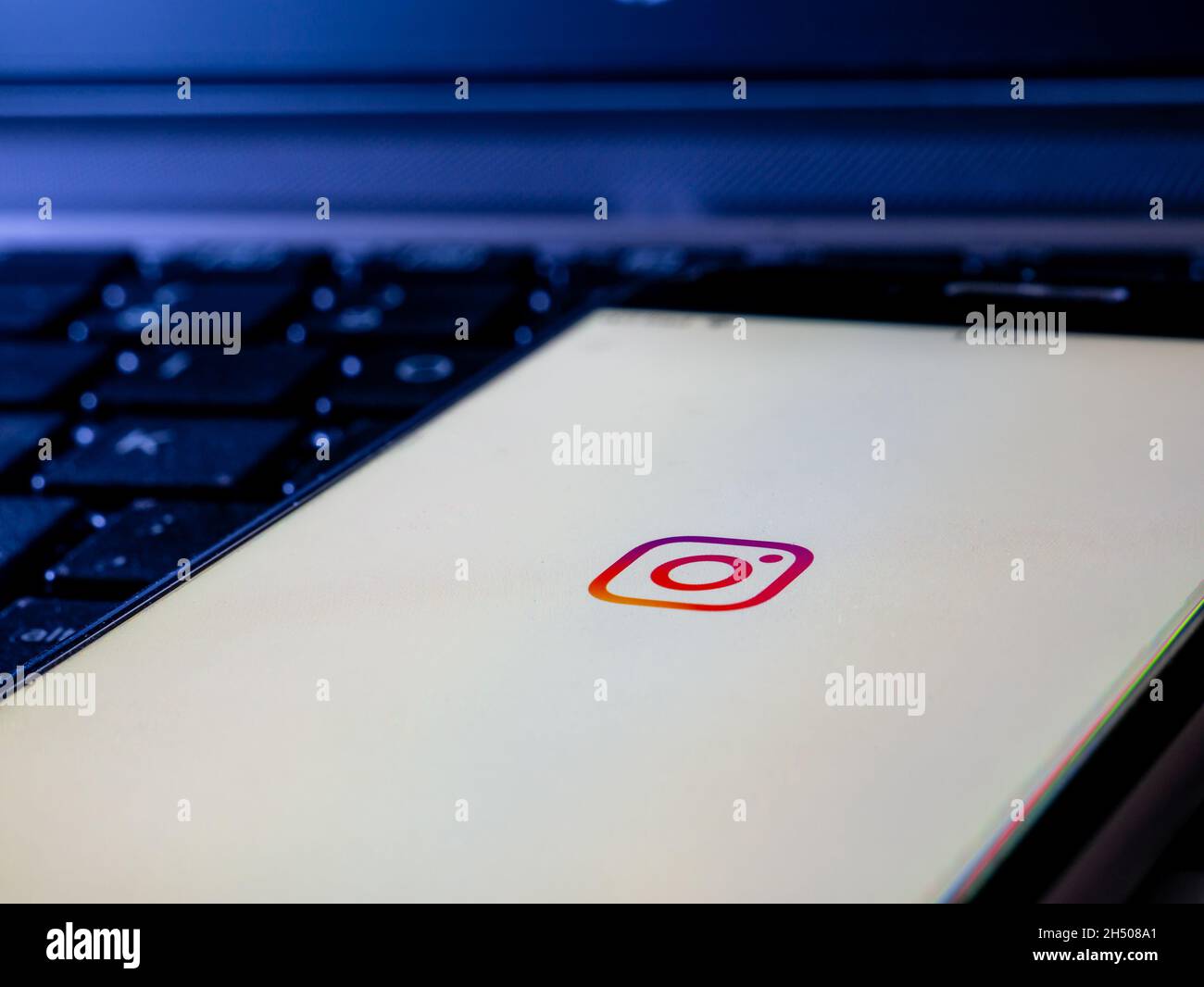 smartphone on a computer keyboard with the screen of the social network Instagram Stock Photo