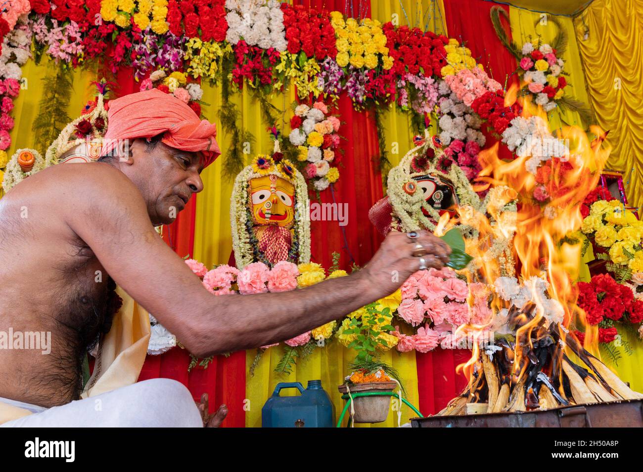 Howrah, West Bengal, India - 29th June 2020 : Hindu priest raising fire of yajna to worship idol of God Jagannath, Balaram and Suvodra. Stock Photo