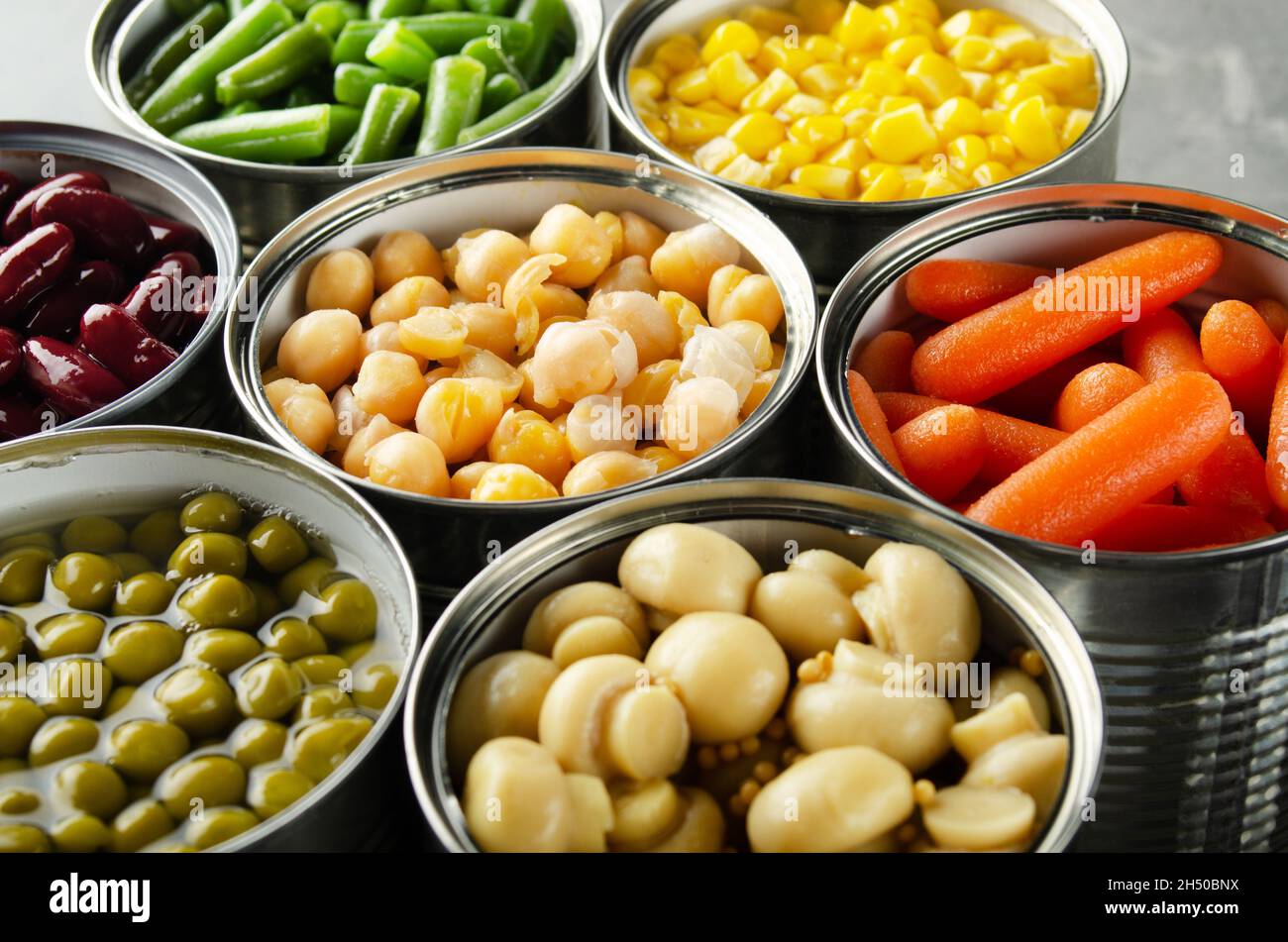 Canned vegetables in opened tin cans on kitchen table. Nonperishable