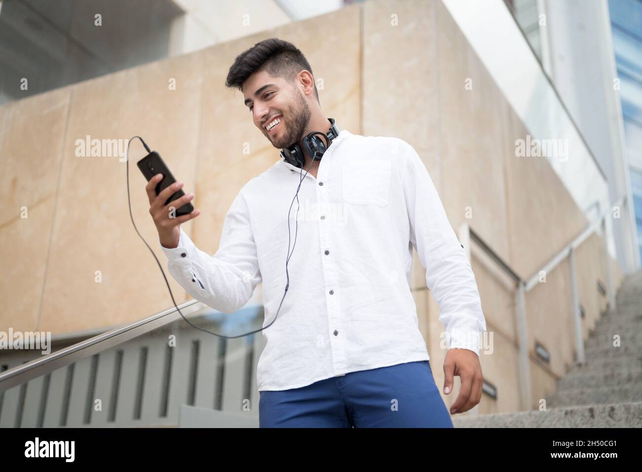 Young handsome hispanic man using smartphone outdoors. High quality photo Stock Photo